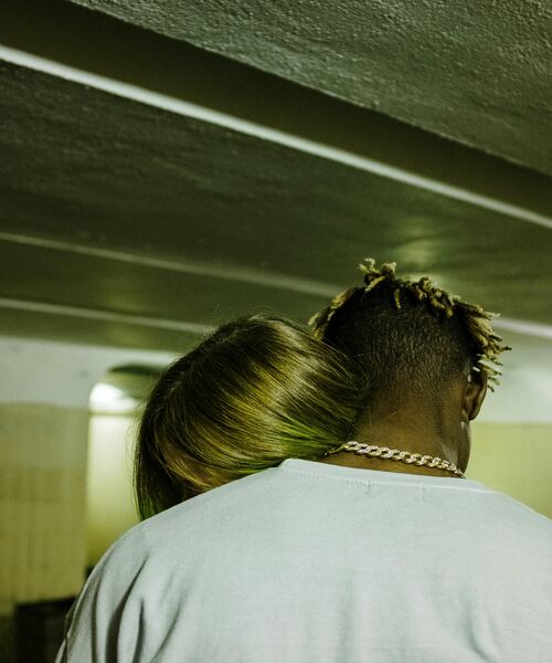 Zwei Personen umarmen sich, die Köpfe lehnen eng aneinander in einer ruhigen, emotionalen Geste.