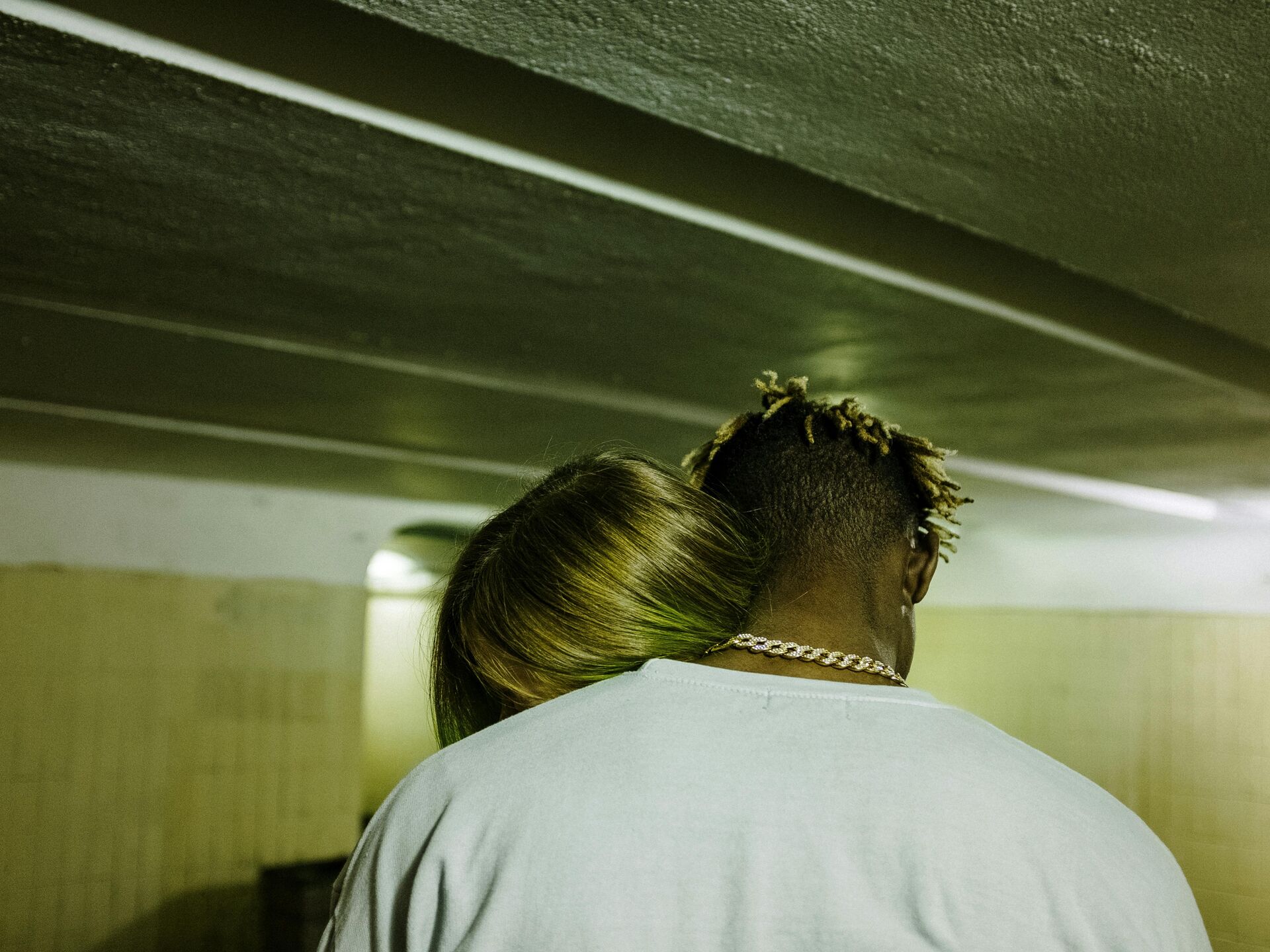 Zwei Personen umarmen sich, die Köpfe lehnen eng aneinander in einer ruhigen, emotionalen Geste.